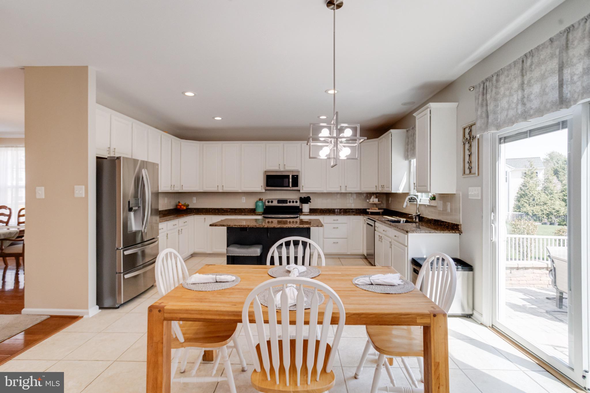 1705 Stone Ridge Court Bel Air, MD 21015 - Photo 23 of 81 a view of a dining room and livingroom with furniture a rug a kitchen island a chandelier and a view of kitchen