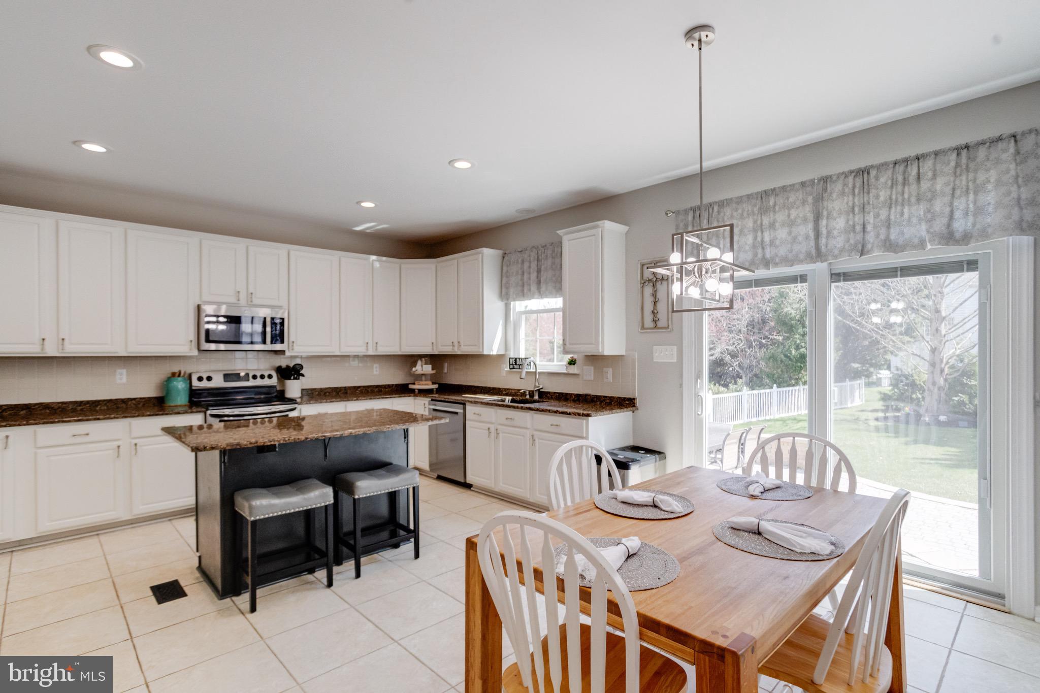 1705 Stone Ridge Court Bel Air, MD 21015 - Photo 24 of 81 a kitchen with stainless steel appliances granite countertop a kitchen island a stove a table and chairs
