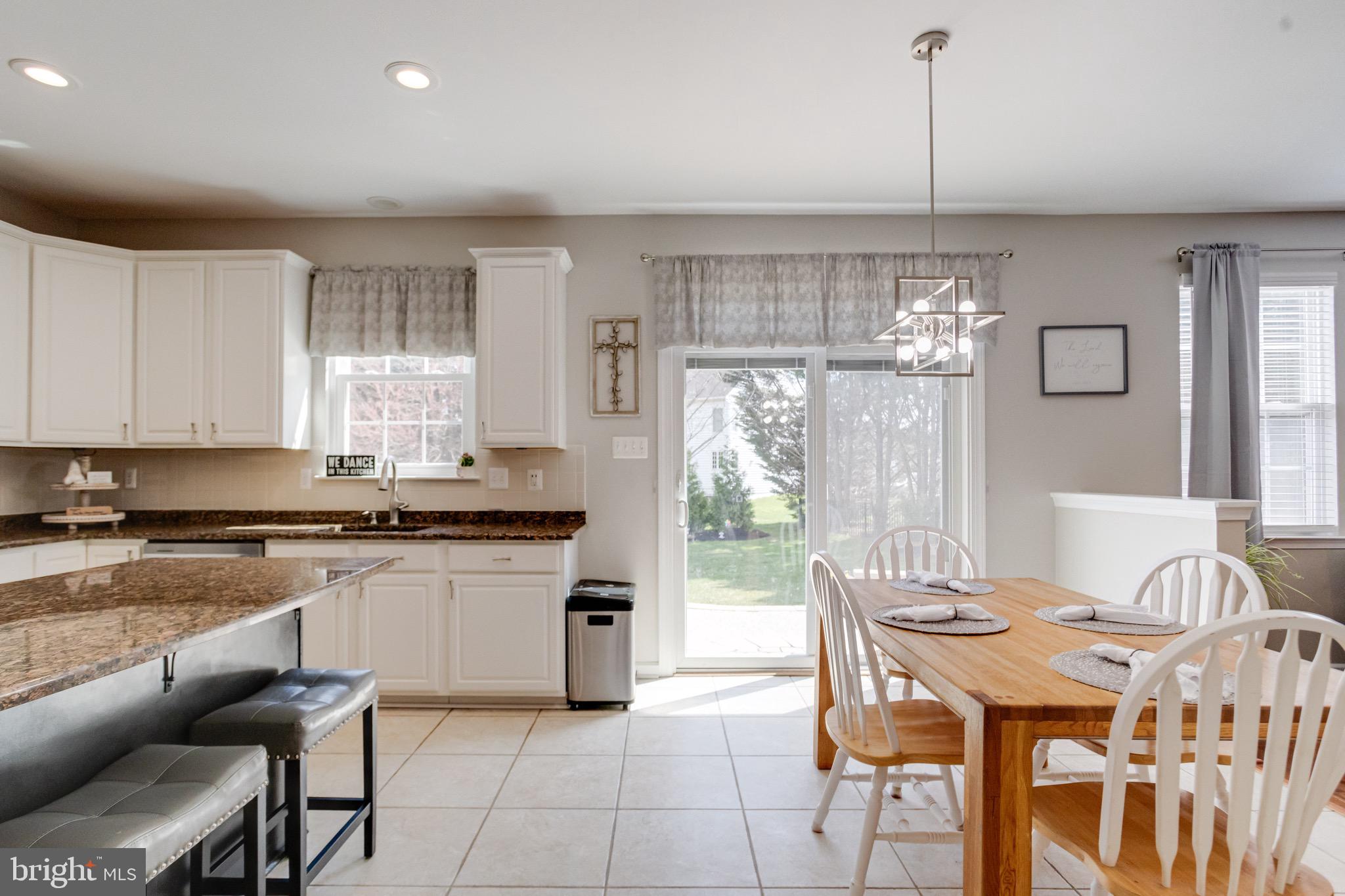 1705 Stone Ridge Court Bel Air, MD 21015 - Photo 25 of 81 a kitchen with stainless steel appliances granite countertop a stove top oven a sink dishwasher a dining table and chairs with wooden floor