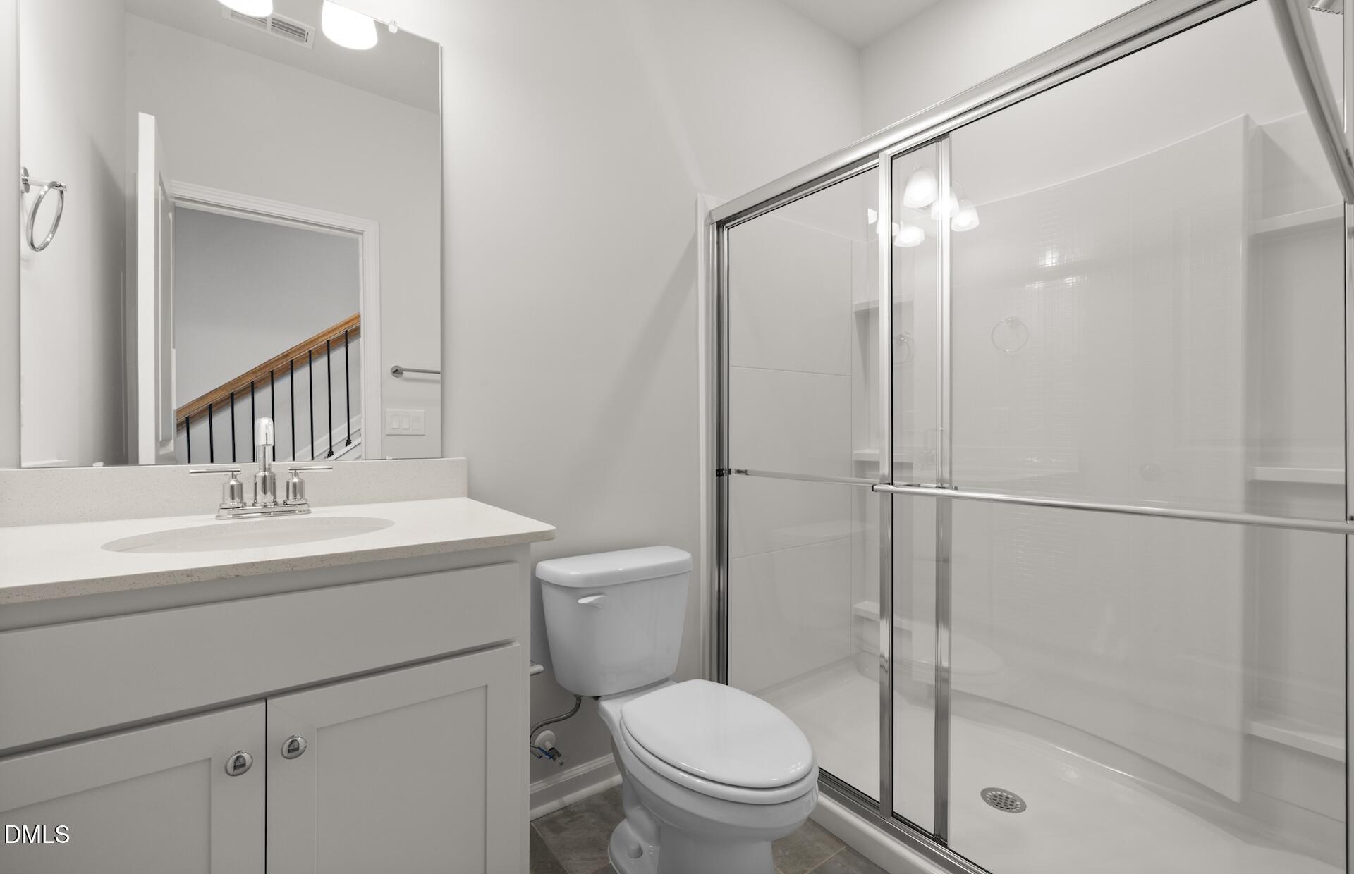 918 Fearless Road Durham, NC 27703 - Photo 16 of 25 a bathroom with a toilet a sink a mirror and shower