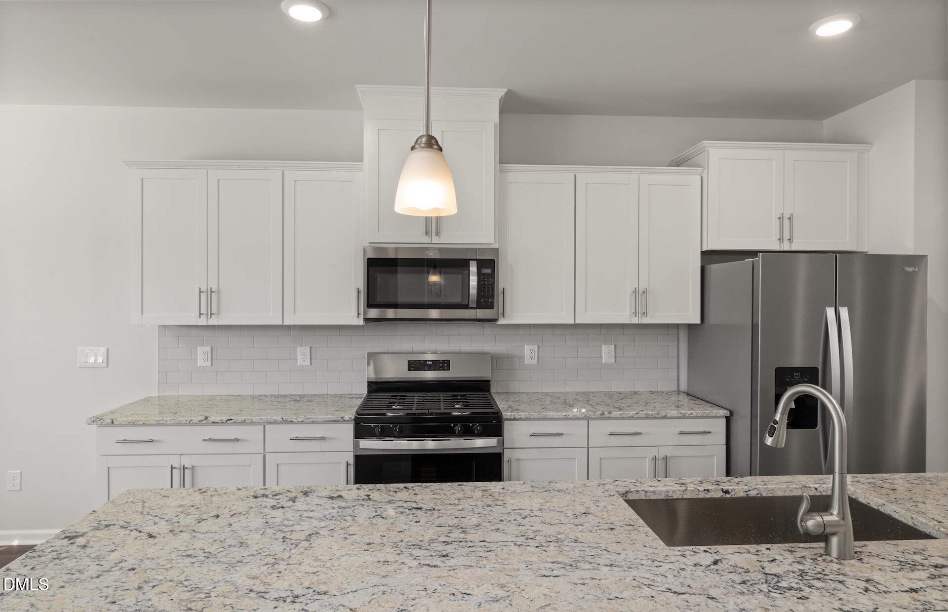 918 Fearless Road Durham, NC 27703 - Photo 5 of 25 a kitchen with stainless steel appliances granite countertop a sink a stove a refrigerator and a granite counter tops