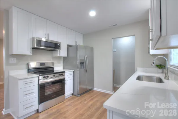 a kitchen with stainless steel appliances a stove sink and microwave
