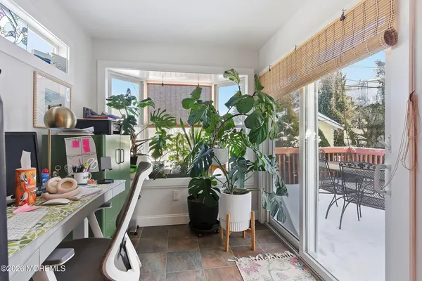 a dining room filled with furniture and a potted plant