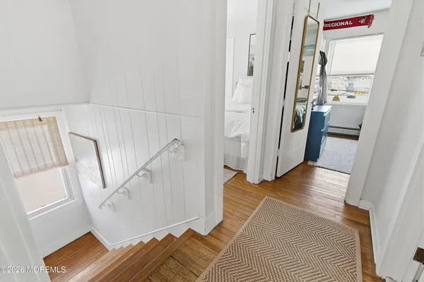 a view of a bedroom with wooden floor and staircase
