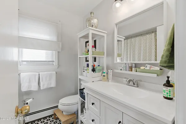 a bathroom with a sink a toilet and a mirror