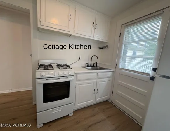 a kitchen with white cabinets and white appliances