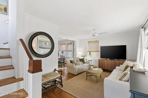 a living room with furniture a mirror and a flat screen tv
