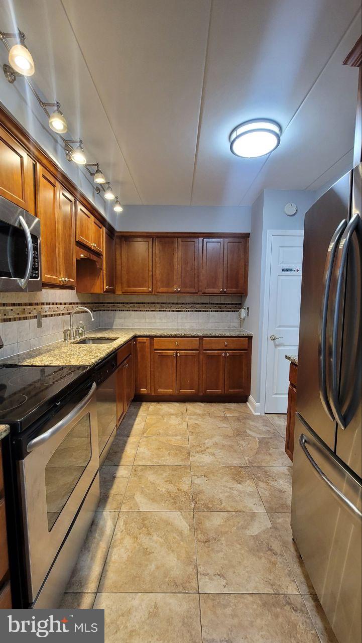 1575 West Street Road, Unit 832 Warminster, PA 18974 - Photo 3 of 14 a large kitchen with stainless steel appliances granite countertop a stove a sink and a microwave