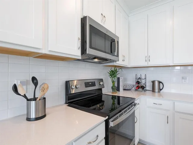 a large kitchen with kitchen island a sink a stove and cabinets