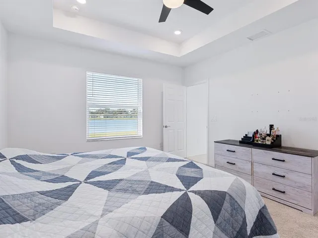 a spacious bedroom with a bed and a chandelier