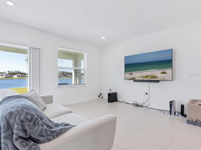 a living room with furniture and a dining table with kitchen view