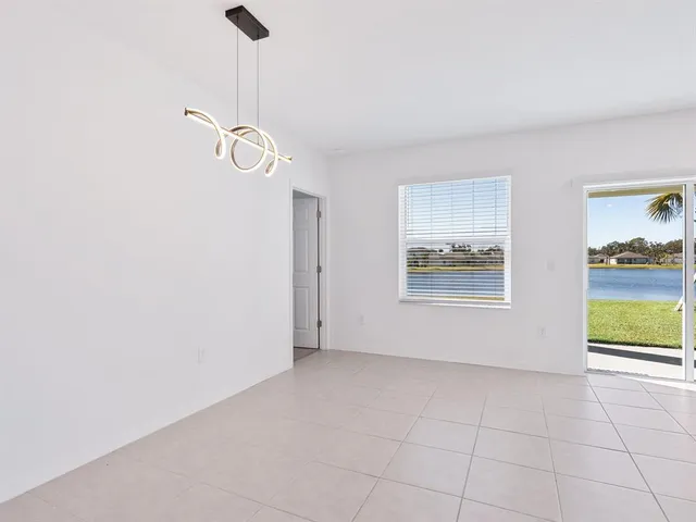 a view of empty room with a chandelier fan and wooden floor