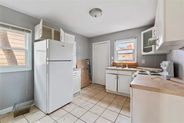 a kitchen with a refrigerator a stove top oven and a window