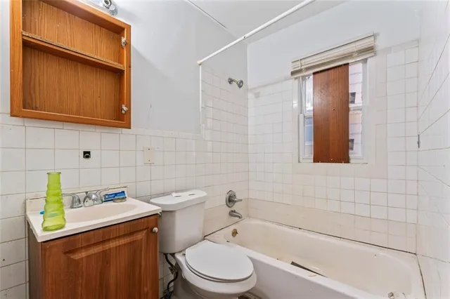 a bathroom with a granite countertop toilet sink and mirror