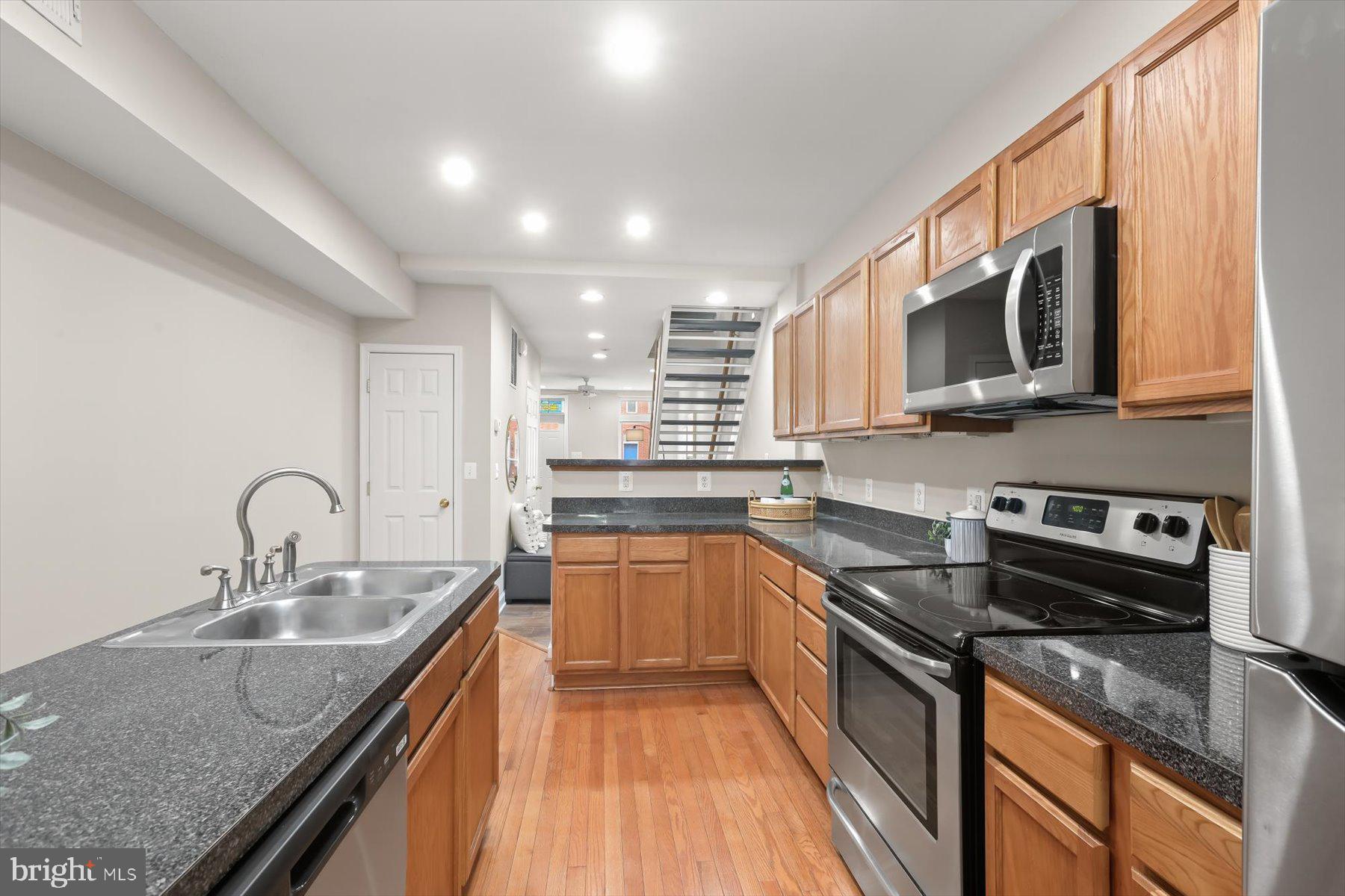 1749 South Hanover Street Baltimore, MD 21230 - Photo 12 of 55 a kitchen with stainless steel appliances granite countertop a sink stove and microwave