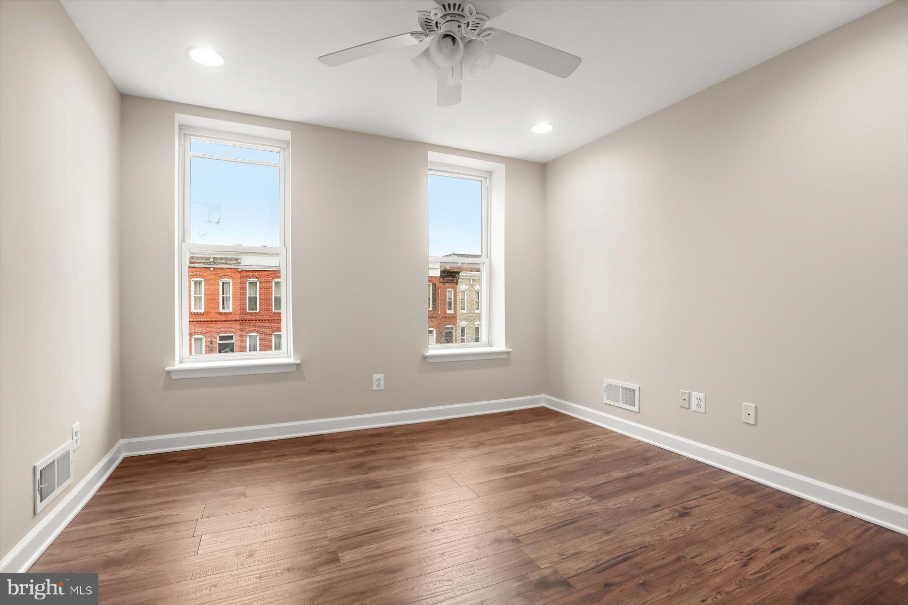 1749 South Hanover Street Baltimore, MD 21230 - Photo 32 of 55 an empty room with wooden floor chandelier and windows