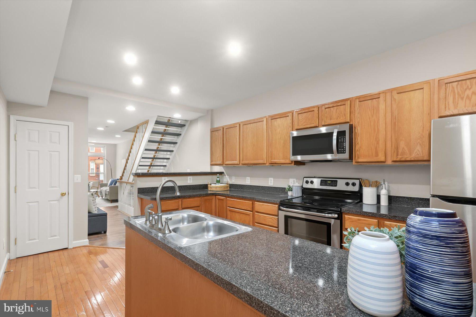 1749 South Hanover Street Baltimore, MD 21230 - Photo 7 of 55 a kitchen with stainless steel appliances granite countertop a stove a sink and a microwave