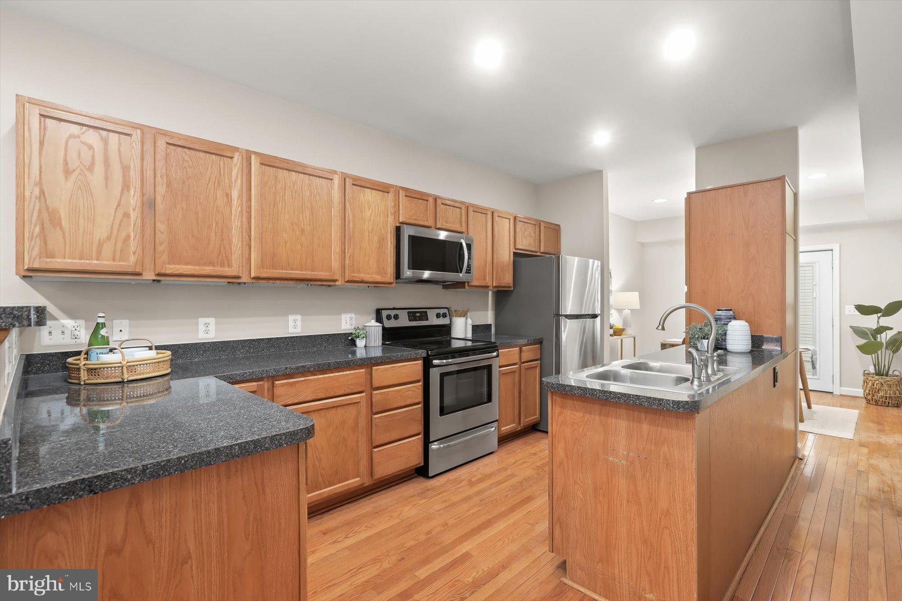 1749 South Hanover Street Baltimore, MD 21230 - Photo 9 of 55 a kitchen with stainless steel appliances granite countertop a sink stove refrigerator and microwave