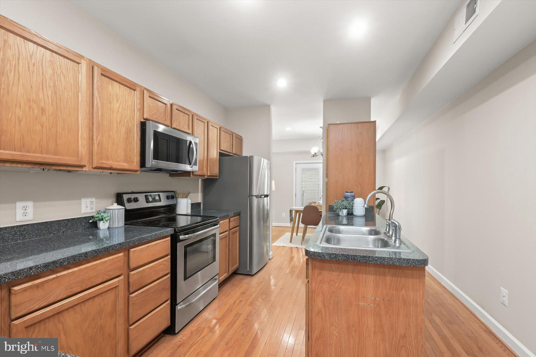 1749 South Hanover Street Baltimore, MD 21230 - Photo 10 of 55 a kitchen with kitchen island granite countertop a sink wooden floor and counter top space
