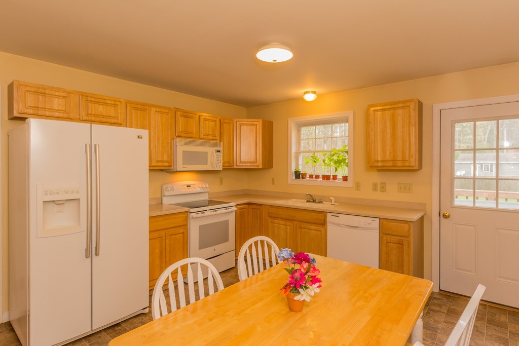 5294 South Athol Road Athol, MA 01331 - Photo 2 of 13 a kitchen with stainless steel appliances granite countertop a refrigerator a sink dishwasher a dining table and chairs with wooden floor