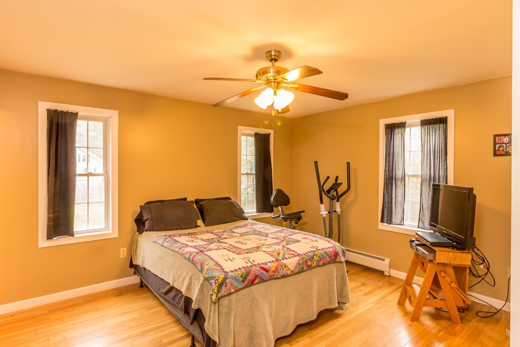 5294 South Athol Road Athol, MA 01331 - Photo 4 of 13 a bedroom with a large bed and a chandelier