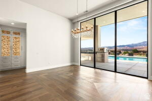 1141 East Lost Ridge Drive Washington, UT 84780 - Photo 46 of 108 Expansive sliding glass doors opening to an outdoor patio with a swimming pool, complemented by wood-finish flooring in a herringbone pattern
