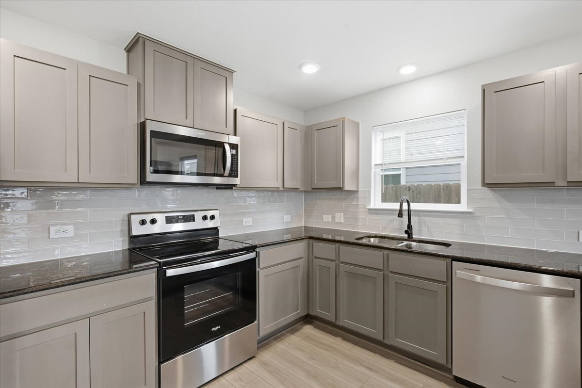 104 Rooster Way Jarrell, TX 76537 - Photo 12 of 33 Polished granite countertops complement sleek contemporary cabinetry in this functional workspace.