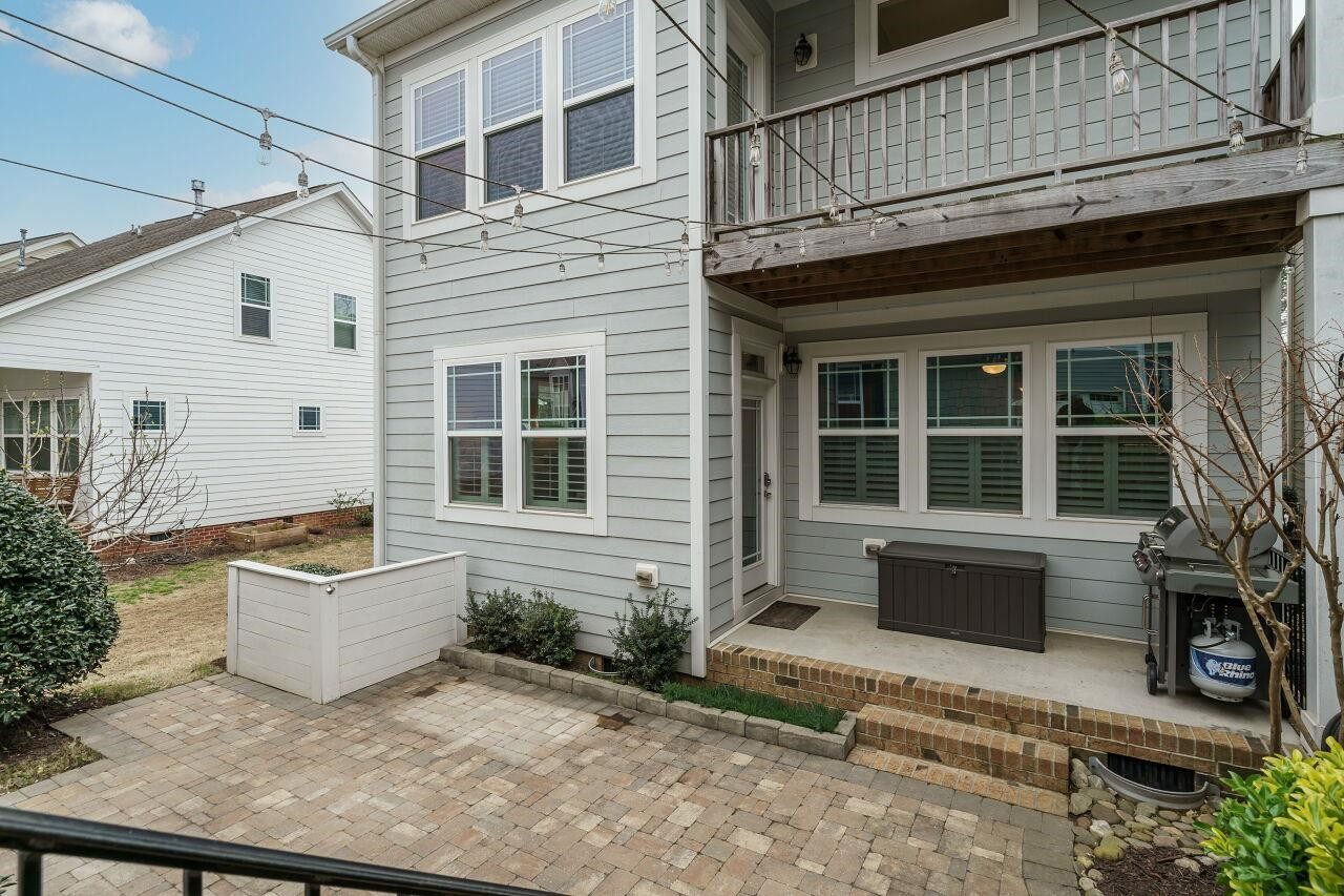 5602 Wade Park Boulevard Raleigh, NC 27607 - Photo 31 of 34 Rear of the home features a view of the owner's balcony, covered porch, paver patio and garden lights that twinkle in the night! Exterior Back
