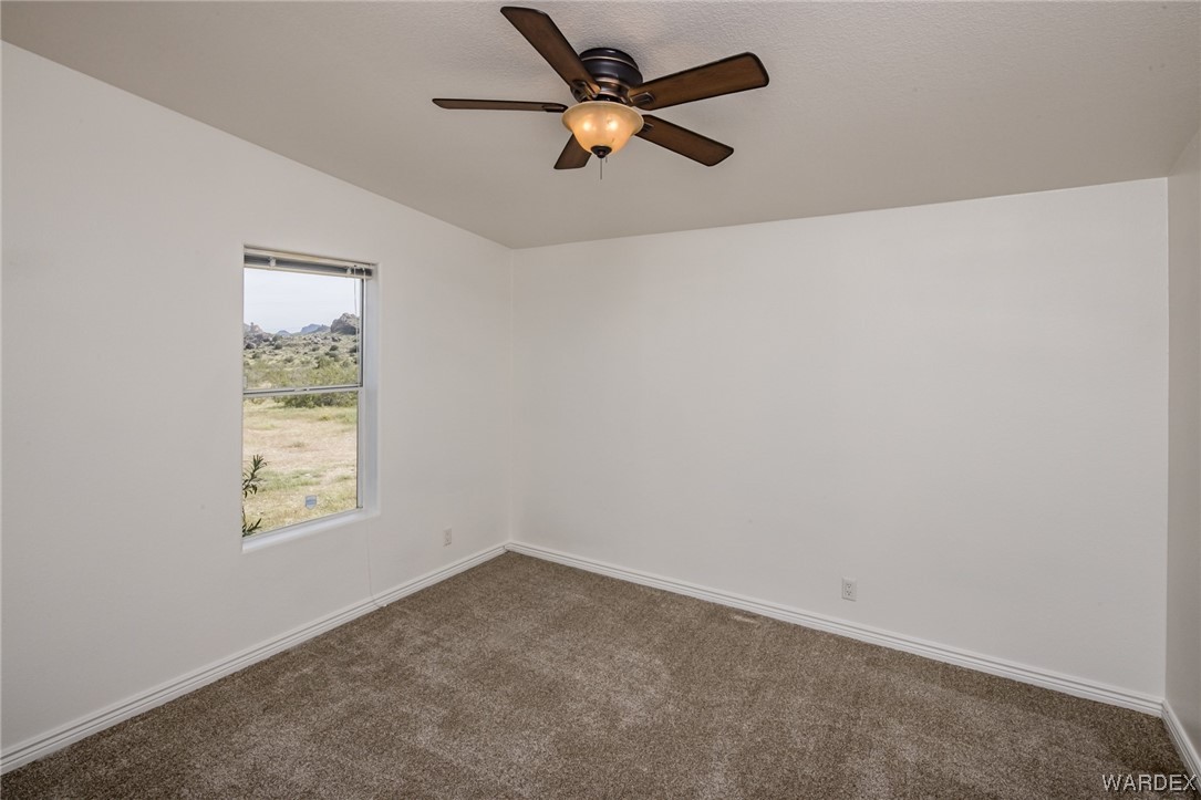 1949 Growler Road Golden Valley, AZ 86413 - Photo 37 of 87 an empty room with a window and a fan