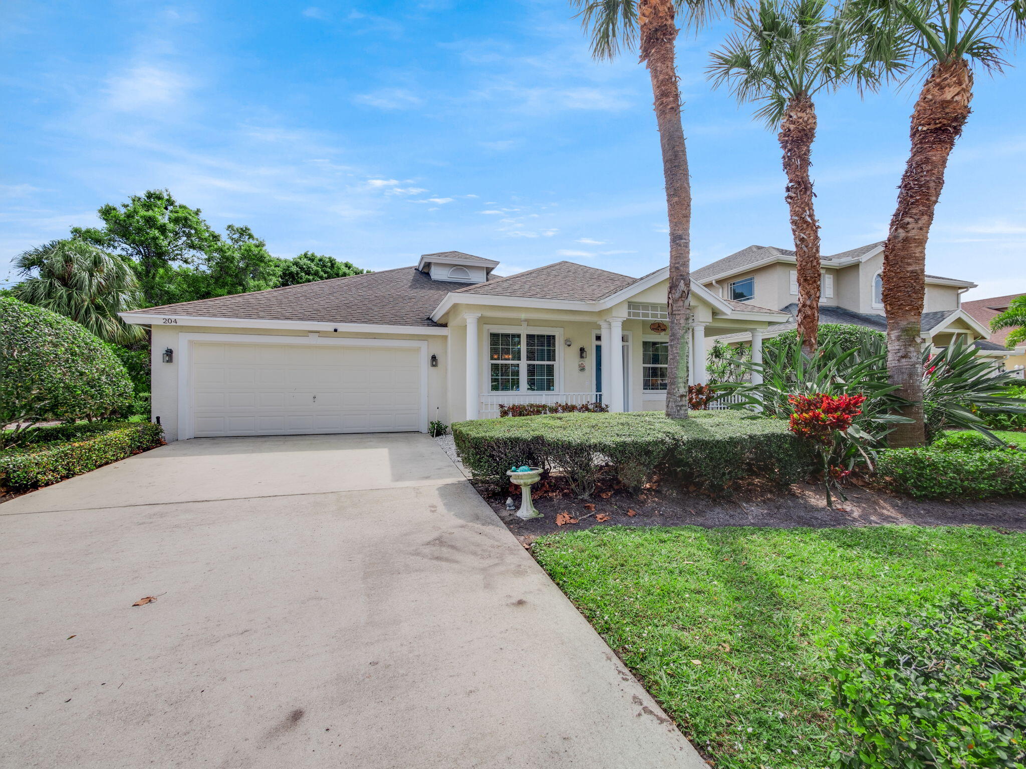 204 Clocktower Drive Jupiter, FL 33458 - Photo 2 of 21 front view of a house with a garden