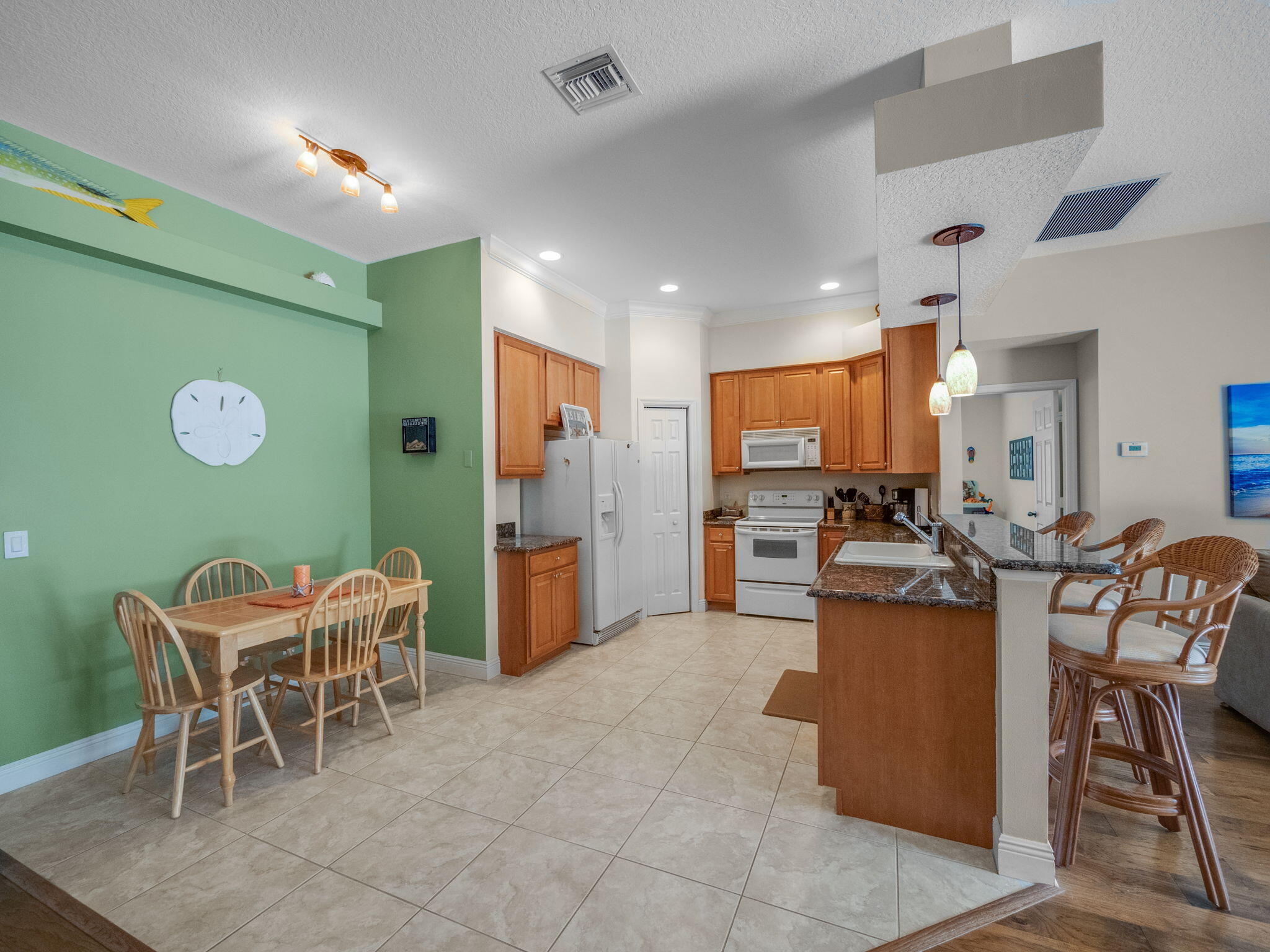 204 Clocktower Drive Jupiter, FL 33458 - Photo 7 of 21 a living room with furniture a dining table and chairs with kitchen view