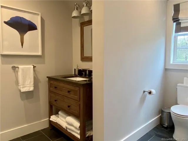 a bathroom with a toilet sink and mirror