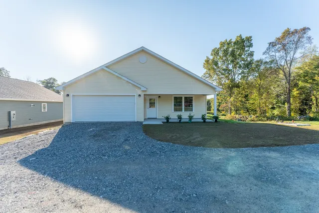 a view of a house with a yard and garage