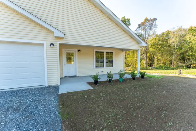 a view of a house with backyard and trees