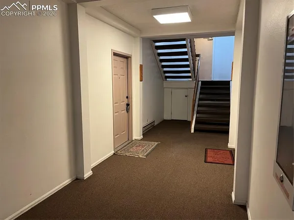 a view of hallway with stairs and wooden floor
