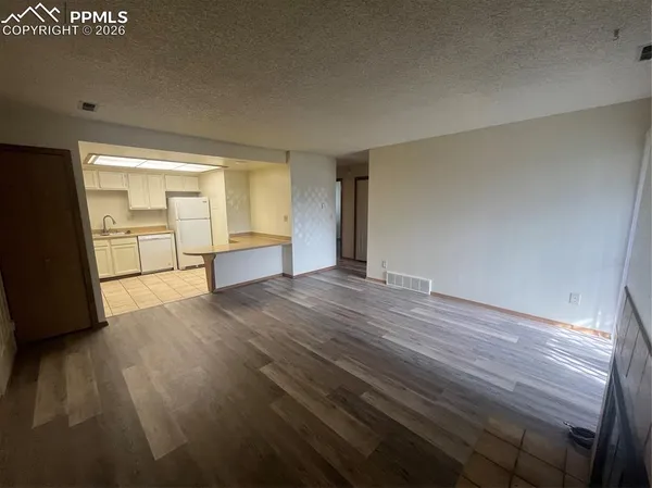 a view of empty room with wooden floor