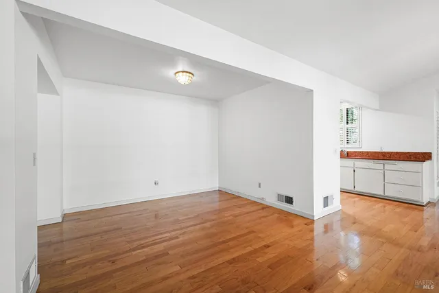 an empty room with wooden floor and fireplace