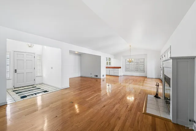 an empty room with windows and fireplace