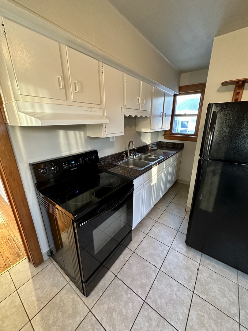 633 Chester Avenue Elgin, IL 60120 - Photo 12 of 29 a kitchen with stainless steel appliances granite countertop a stove a sink and a microwave