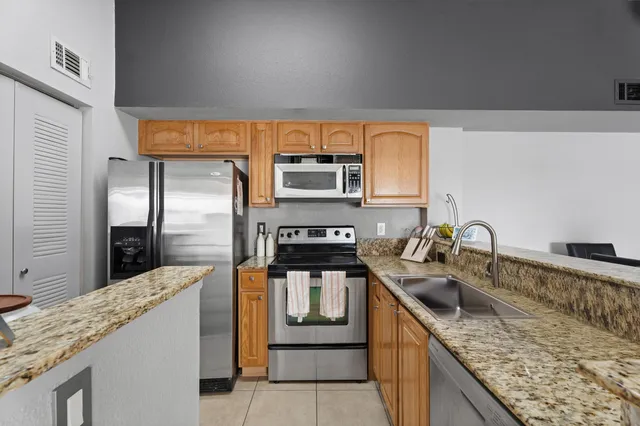 a kitchen with stainless steel appliances granite countertop a sink stove and refrigerator