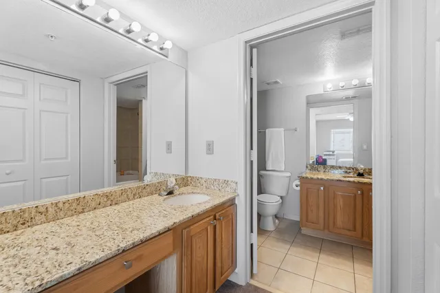 a bathroom with a granite countertop sink a toilet and shower
