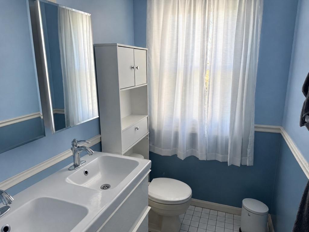38 Crescent Road, Unit 38 Needham, MA 02494 - Photo 17 of 23 a bathroom with a sink toilet a mirror and shower curtain