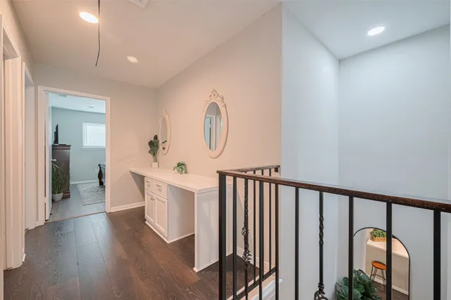 a view of a hallway with wooden floor and windows
