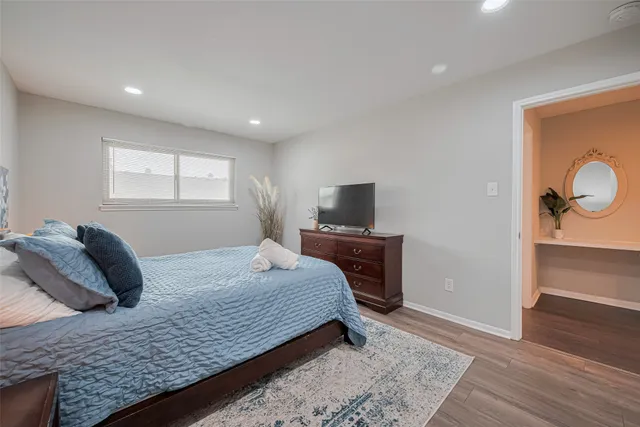 a bedroom with a bed and wooden floor
