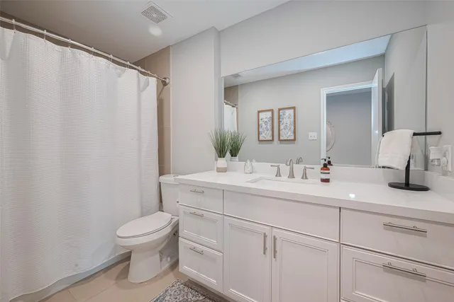 a spacious bathroom with a toilet sink and mirror