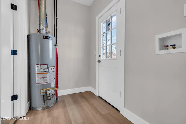 an empty room with wooden floor closet and windows