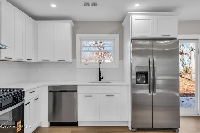a kitchen with stainless steel appliances granite countertop a stove a sink and a refrigerator
