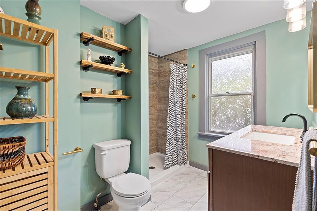 406 Center Road Monroeville, PA 15146 - Photo 18 of 25 a bathroom with a sink a toilet and shower curtain