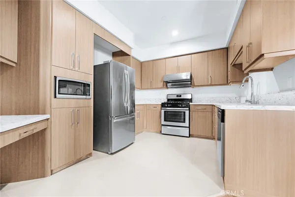 a kitchen with stainless steel appliances granite countertop a refrigerator stove and a sink