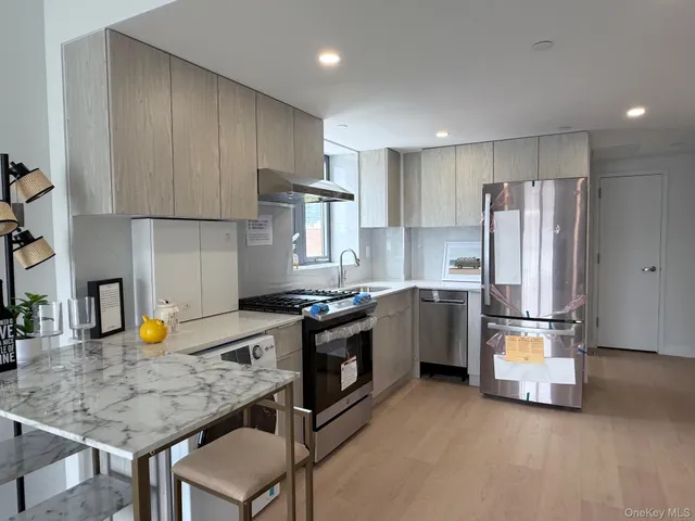 a kitchen with stainless steel appliances a stove a sink a refrigerator and cabinets